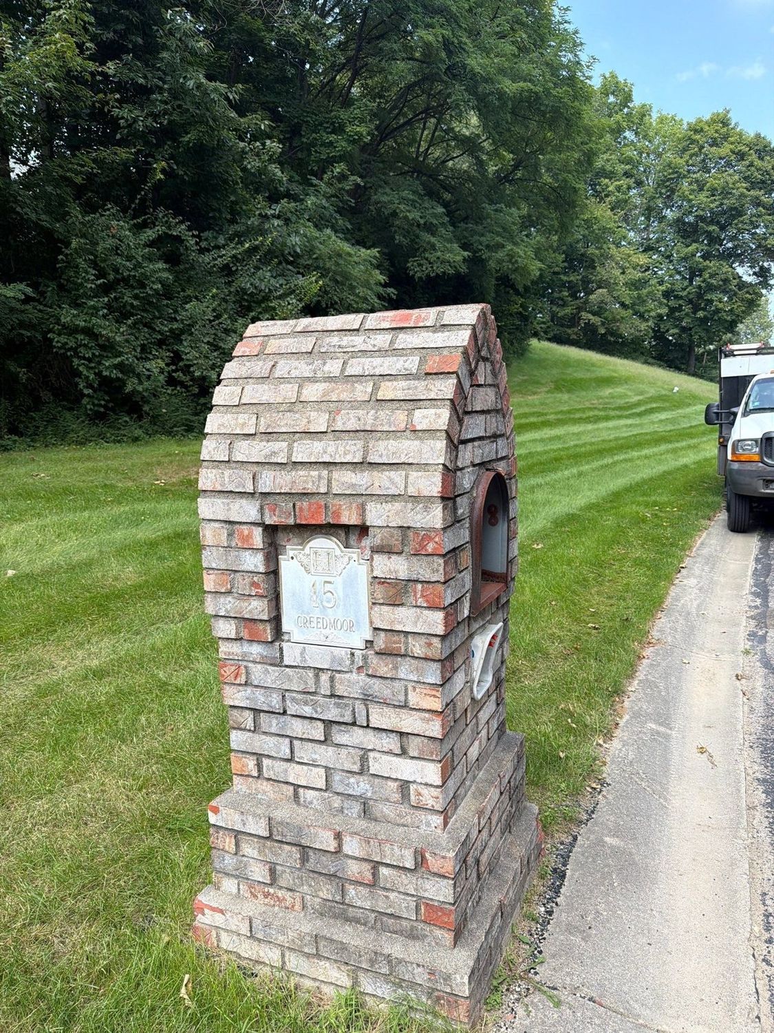 Brick mailbox column beside a driveway after masonry cleaning in Anderson