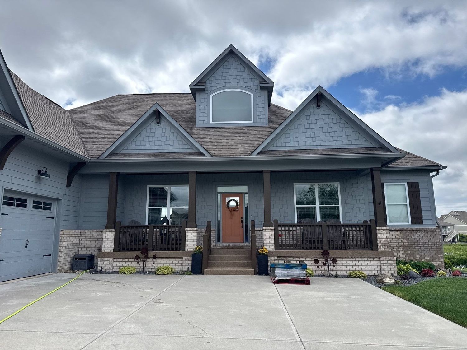 Blue craftsman style Westfield home with a cleaned drive and porch