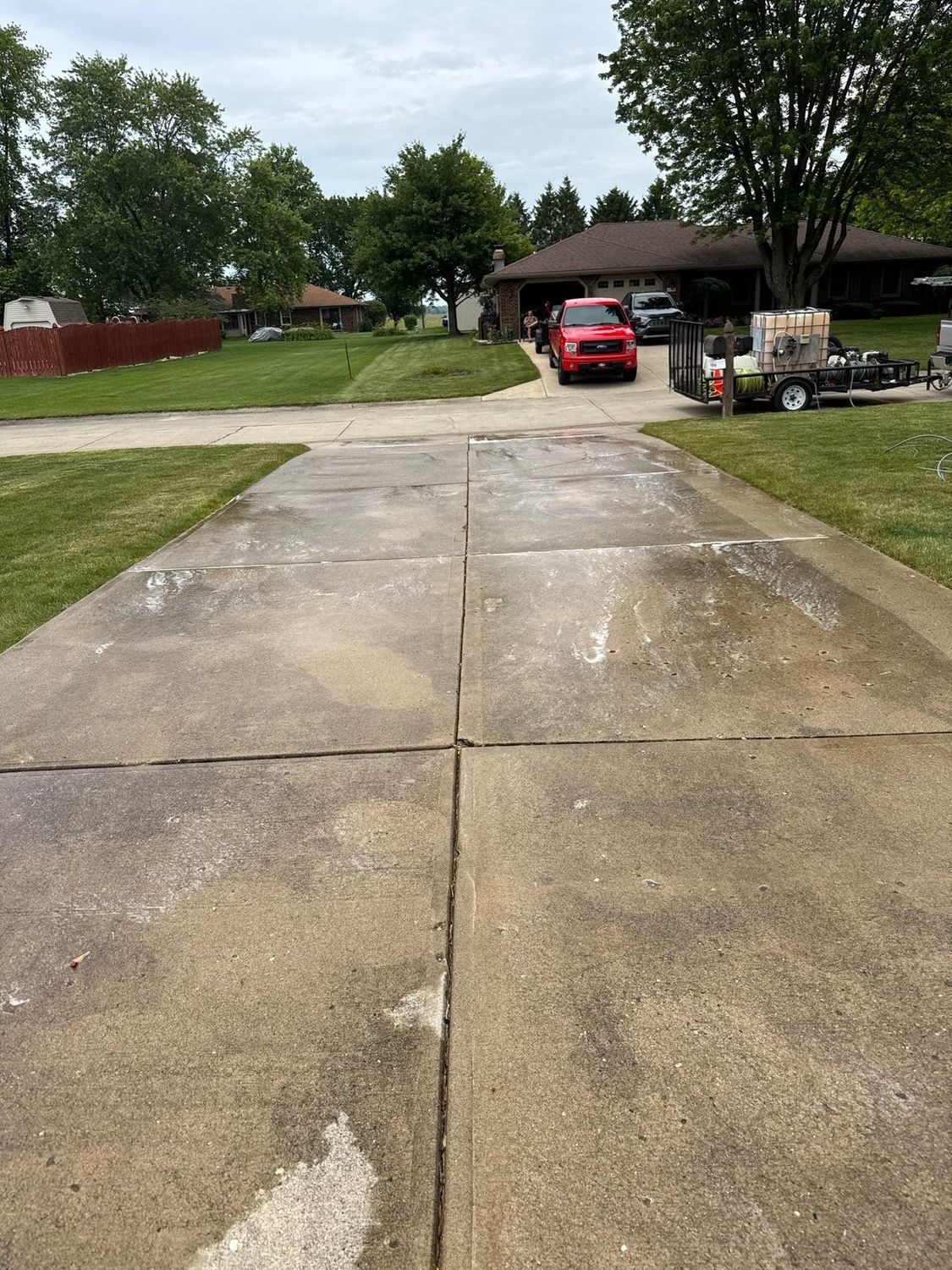 Cleaned concrete driveway running to the street at an Anderson home
