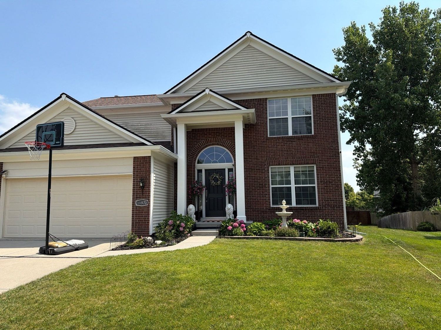 Large brick Fishers home with a cleaned drive and cut lawn